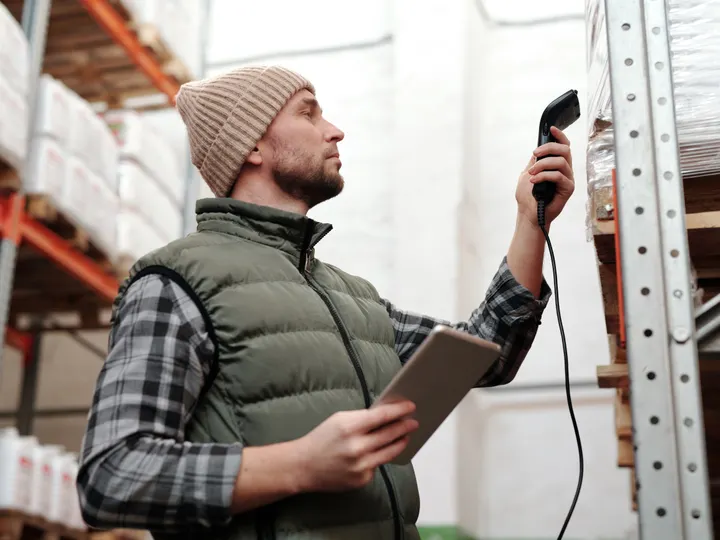 Warehouse worker scanning inventory on storage racks