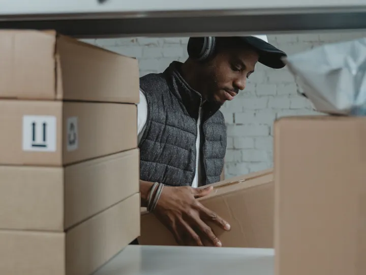 Warehouse worker sorting parcels in a packing area